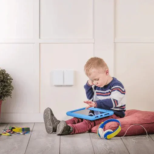 Toddler plays with iPad sitting next to electric plug cover